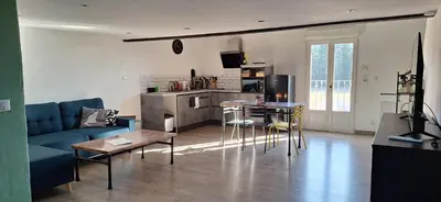 a living room with a blue couch and a kitchen at Complexe dans un grand Mas Provençal en campagne avec piscine privée in Monteux
