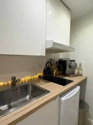 a kitchen with white cabinets and a sink at Studio de Charme, Plein centre in LʼIsle-sur-la-Sorgue
