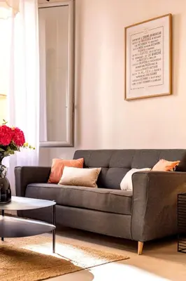 a living room with a grey couch and a table at Charme et Modernité au coeur d'Aix & Cours Mirabeau in Aix-en-Provence