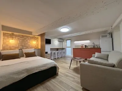 a bedroom with a bed and a couch and a kitchen at Magnifique studio centre d'Aix & Cours Mirabeau in Aix-en-Provence
