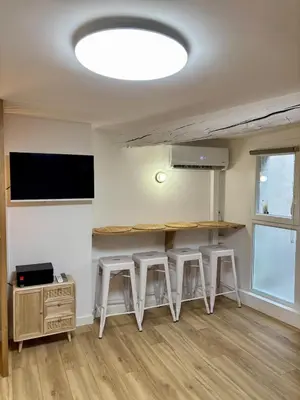 a room with three stools and a counter with a tv at Magnifique studio centre d'Aix & Cours Mirabeau in Aix-en-Provence
