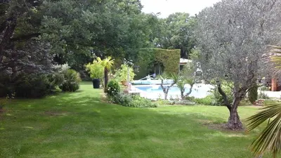 a yard with a swimming pool and some trees at AU BONHEUR et LIBERTÉ in Meyrargues