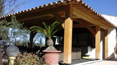 a wooden pergola with a plant in a pot at AU BONHEUR et LIBERTÉ in Meyrargues