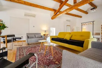 a living room with a yellow couch and a rug at Gite dans un Mas Provençal avec Jacuzzi in Oppède