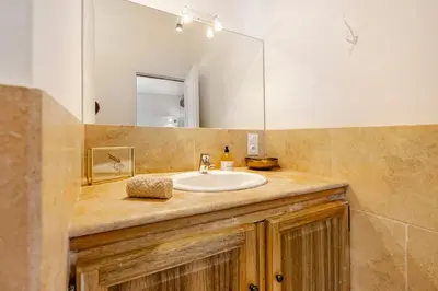 a bathroom with a sink and a mirror at Gite dans un Mas Provençal avec Jacuzzi in Oppède