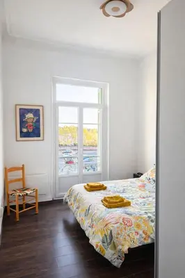a bedroom with a yellow bed and a window at Cozy apartment in LʼIsle-sur-la-Sorgue