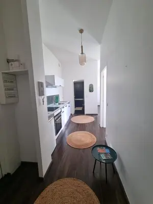a living room with two tables and a kitchen at Cozy apartment in LʼIsle-sur-la-Sorgue