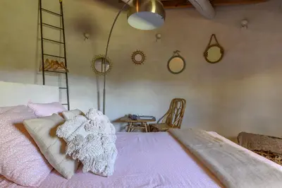 a bedroom with a bed and a table and a chair at Gîte de charme face au Luberon, avec Jacuzzi in Oppède