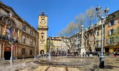 a city street with a clock tower in the distance at Le Jardinet de la Cathédrale in Aix-en-Provence