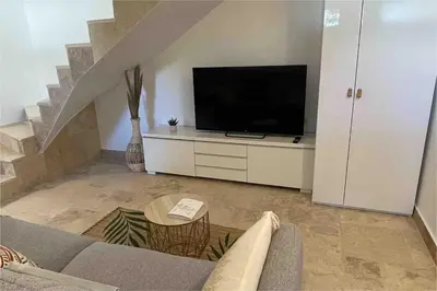 a living room with a couch and a flat screen tv at Duplex indépendant avec clim et parking St Donat in Aix-en-Provence