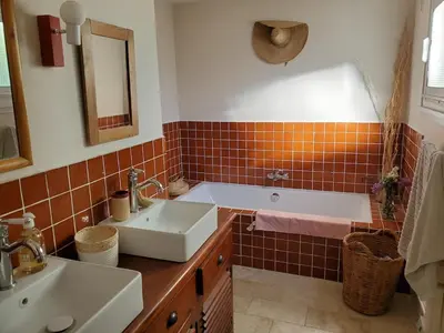 a bathroom with a tub and a sink and a mirror at Charming house near village with 5-minutes pedestrian access to old town in Venelles