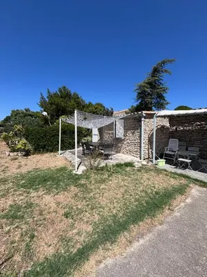 a stone house with a picnic table and chairs at Le pavé in Gordes