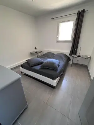 a bed in a white room with a window at Le pavé in Gordes