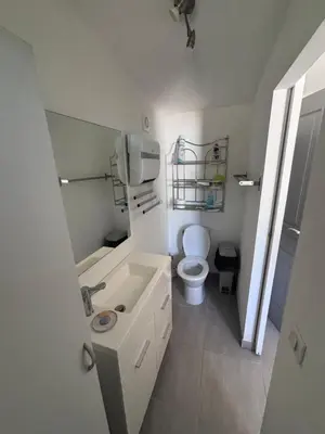 a white bathroom with a toilet and a sink at Le pavé in Gordes