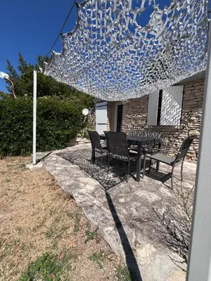 a patio with chairs and a table with a glass structure at Le pavé in Gordes