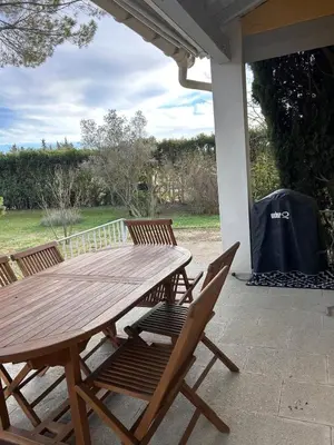 a wooden table and chairs on a patio at Le Paradis au centre du Vaucluse in Saumane-de-Vaucluse