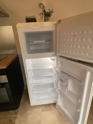 an empty refrigerator with its door open in a kitchen at Vacances face au Luberon in Robion en Luberon