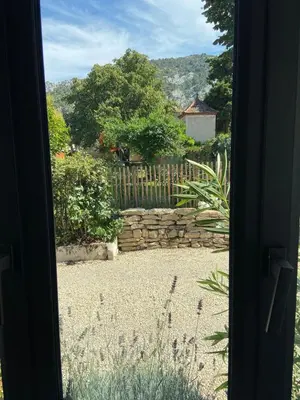 a view of a garden through a door at Vacances face au Luberon in Robion en Luberon
