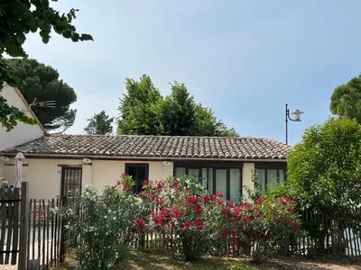 a house with flowers in front of a fence at Vacances face au Luberon in Robion en Luberon