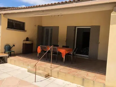 a patio with a table and chairs on it at La maison du bon remède in Mazan