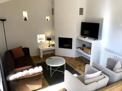 a living room with a couch and chairs and a tv at La maison du bon remède in Mazan