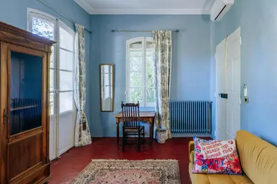 a living room with blue walls and a table at Chateau du Jonquier in Mazan