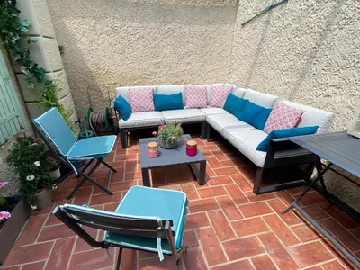 a patio with a couch and chairs and a table at Sejour paisible au Thor in Le Thor