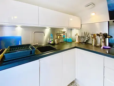 a kitchen with white cabinets and a sink at Sejour paisible au Thor in Le Thor
