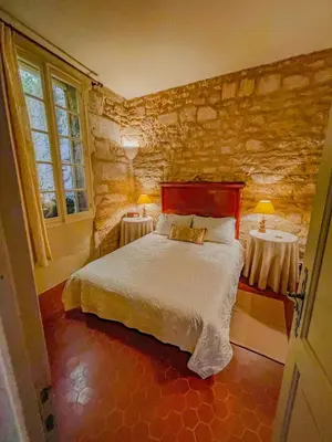 a bedroom with a bed and two tables at Maison de charme au coeur du village de Gordes in Gordes