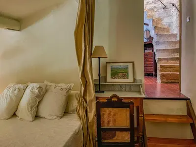 a bedroom with a bed with a table and a window at Maison de charme au coeur du village de Gordes in Gordes