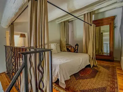 a bedroom with a bed in a room with a window at Maison de charme au coeur du village de Gordes in Gordes