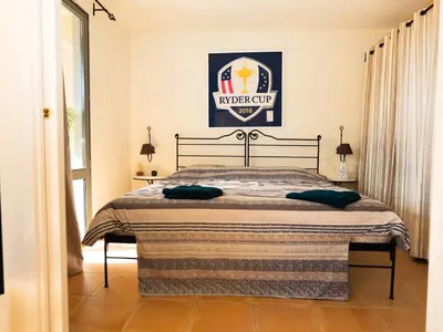 a bed in a room with a poster on the wall at Appartement au coeur du Golf de Saumane in Saumane-de-Vaucluse