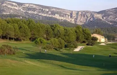 a golf course with trees and a mountain in the background at Appartement au coeur du Golf de Saumane in Saumane-de-Vaucluse