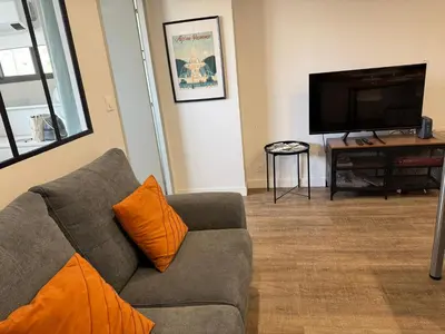 a living room with a couch and a flat screen tv at Chez Edouard - Superbe Triplex neuf - 6 chambres - Centre ville proche Rotonde allées provençales in Aix-en-Provence