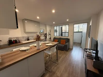 a kitchen and living room with a table and a couch at Chez Edouard - Superbe Triplex neuf - 6 chambres - Centre ville proche Rotonde allées provençales in Aix-en-Provence
