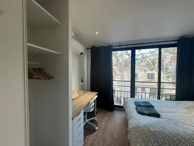 a bedroom with a bed and a desk and a window at Chez Edouard - Superbe Triplex neuf - 6 chambres - Centre ville proche Rotonde allées provençales in Aix-en-Provence