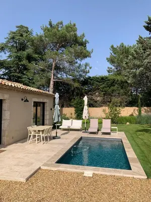 a swimming pool in a yard with chairs and a table at Mazet LEAJO 2 in Eygalières