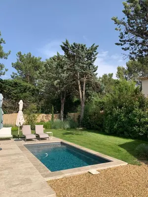 a swimming pool in a yard with two lounge chairs at Mazet LEAJO 2 in Eygalières