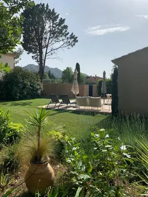 a yard with a patio with chairs and a table at Mazet LEAJO 2 in Eygalières