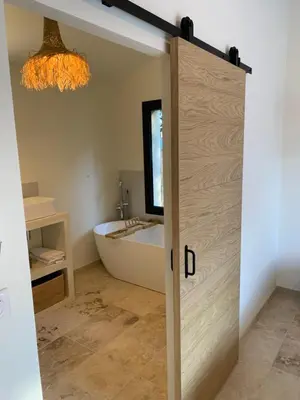 a bathroom with a door leading to a tub at Mazet LEAJO 2 in Eygalières
