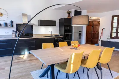 a dining room with a wooden table and yellow chairs at Appartement centre Aix Terrace et ascenseur in Aix-en-Provence