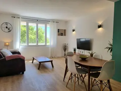 a living room with a table and a tv at Bright T2 - parking - AC in Aix-en-Provence