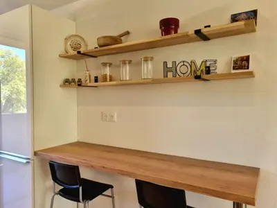 a bar in a kitchen with two chairs and shelves at Bright T2 - parking - AC in Aix-en-Provence