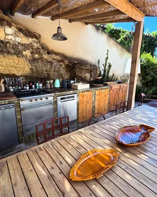 an outdoor kitchen with a wooden table with a counter top at CaBaNa 52 La chambre Proche Lourmarin in Cadenet