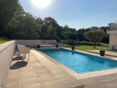 a swimming pool with a table and chairs in a yard at Les escapades Provençales in Aix-en-Provence