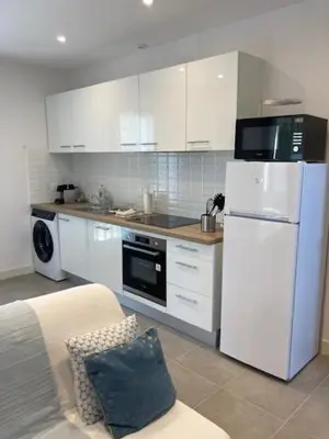 a kitchen with white cabinets and a white refrigerator at Les escapades Provençales in Aix-en-Provence