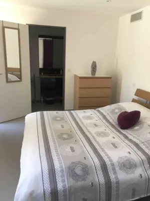 a bedroom with a bed with a red pillow on it at Les escapades Provençales in Aix-en-Provence