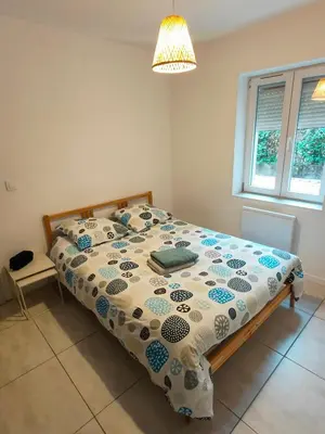 a bedroom with a bed with a comforter on it at Joli appartement Urbain in Cavaillon