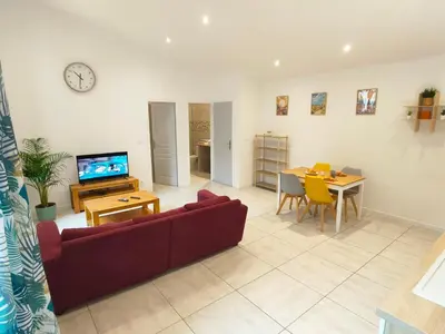 a living room with a couch and a dining room at Joli appartement Urbain in Cavaillon