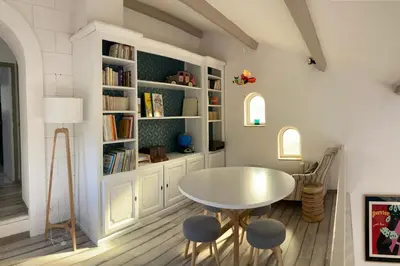 a dining room with a table and chairs and bookshelves at Beautiful Property Isle-sur-la-Sorgue in LʼIsle-sur-la-Sorgue